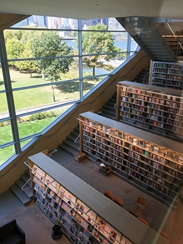 Three levels of library with bookshelves and windows