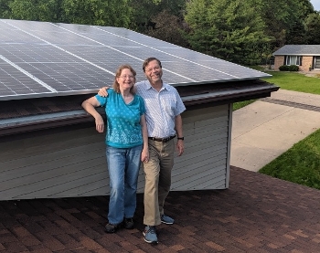 Carol and Andy Phelps on roof in front of new solar panels