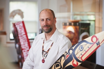 Ry Moran holding ceremonial painted paddle