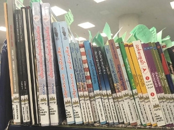 row of Khmer-language books on shelf
