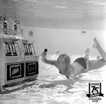 black & white photo of woman in bikini playing mid-century slot machine underwater
