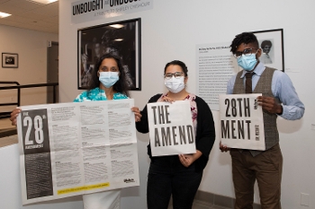 three BPL workers holding 28th amendment signs and material
