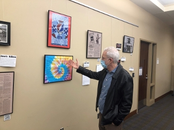 Eric Mlyn in front of Grateful Dead archival material displayed on wall