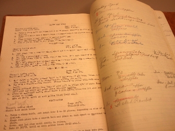 old home economics textbook with penciled annotations around recipes