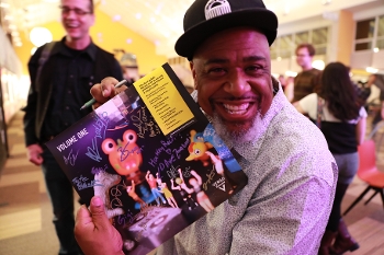 smiling man holding up Verso Records album