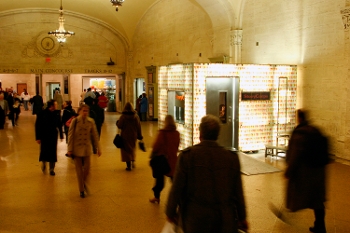 exterior of StoryCorps booth in Grand Central Station with people walking past