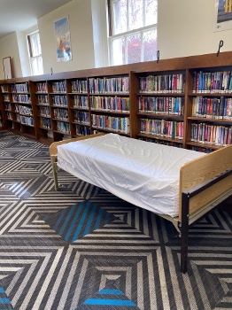 library with wall of bookshelves and bed
