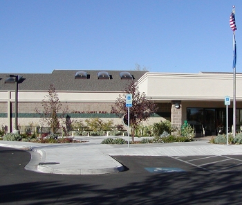 Douglas County Library Minden location exterior, low building with parking lot and flagpole