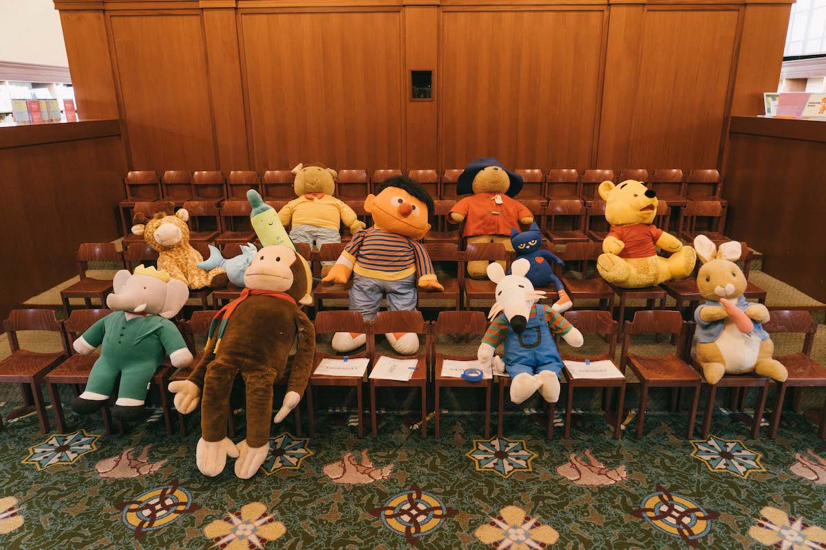 rows of children sized chairs with stuffed animals in them, including Ernie, Peter Rabbit, Winnie-the-Pooh