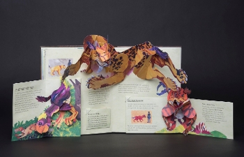 interior of pop-up book with beast jumping across spread, dinosaurs to either side
