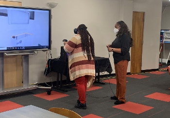 Two women inside a Clayton County Library System branch  (one in a VR headset using the VR job training program)